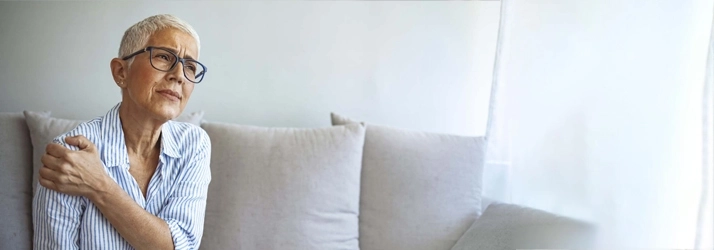 Woman holding her shoulder in pain